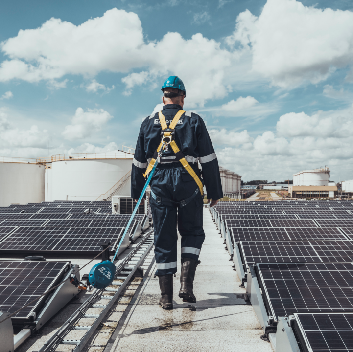 Man in overalls walking between solar panels